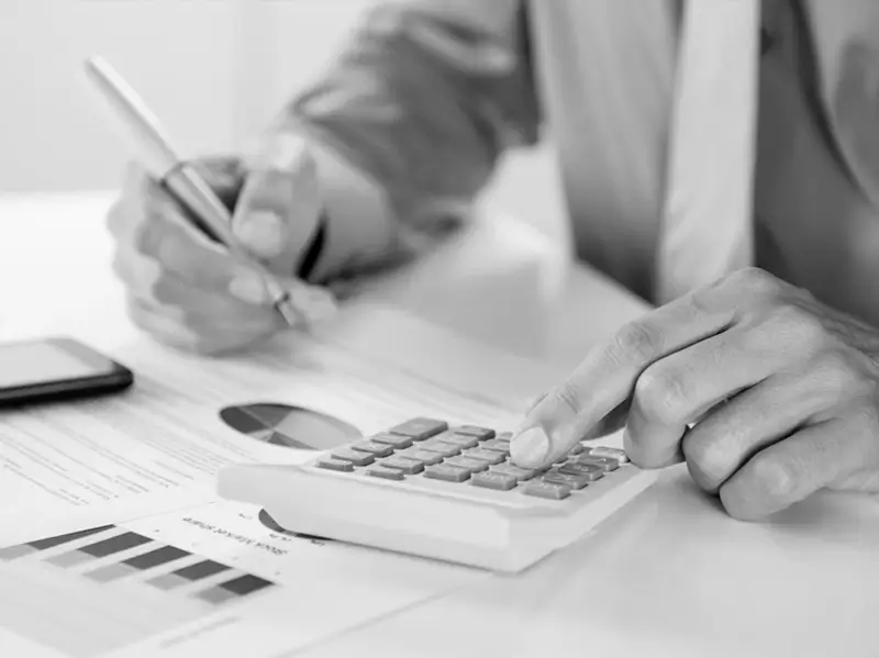 Advogado analisando documentos financeiros e usando calculadora - serviços de direito tributário